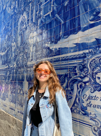 Christina posing with a typical portuguese tile panel behind